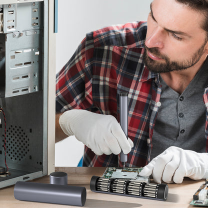 Man working on a computer motherboard with tools and components on a table.